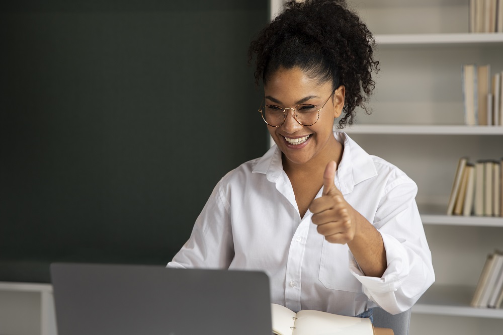 Mujer mira en su laptop un recorrido virtual de departamento y levanta el pulgar